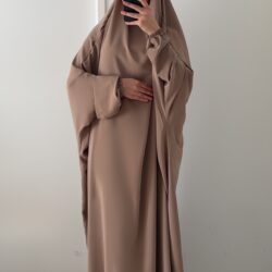 Élégance, confort et qualité française réunis dans un jilbab d'exception Laisse-toi séduire par notre jilbab en soie de Médine, une pièce à la fois raffinée, fluide et incroyablement agréable à porter. Conçu avec soin et fabriqué en France, ce jilbab allie un savoir-faire local à une matière d’exception, pensée pour sublimer chaque silhouette avec simplicité et élégance. La soie de Médine est une matière prisée pour sa texture douce, légèrement satinée et parfaitement opaque. Elle tombe avec grâce, sans coller à la peau, tout en apportant un tombé fluide qui accompagne naturellement les mouvements. C’est le tissu idéal pour celles qui recherchent à la fois confort et style, que ce soit pour un usage quotidien ou des occasions spéciales. Ce modèle a été pensé pour s’adapter à toutes les morphologies, grâce à sa coupe ample et fluide qui garantit une liberté de mouvement optimale tout en respectant les exigences de pudeur. La mannequin mesure 1m66 et porte le jilbab en taille standard : il offre une couvrance parfaite sans traîner au sol, avec un haut ajusté sans serrer et un bas évasé qui allonge la silhouette tout en douceur. Le petit plus ? Ce jilbab est 100 % made in France, fabriqué dans nos ateliers avec une attention minutieuse portée aux finitions. Chaque pièce est cousue avec soin pour t’assurer une tenue impeccable lavage après lavage. Disponible en plusieurs coloris soigneusement sélectionnés, ce jilbab s’intègre parfaitement dans une garde-robe moderne et minimaliste. Une pièce incontournable pour celles qui veulent allier modestie, féminité et qualité sans faire de compromis.